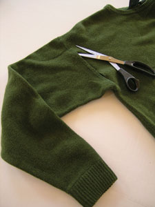Cut the sleeve off of a fluffy old sweater with a wide sleeve and a ribbed cuff. Try to cut on the other side of the shoulder seam so the stitching keeps threads from unraveling.